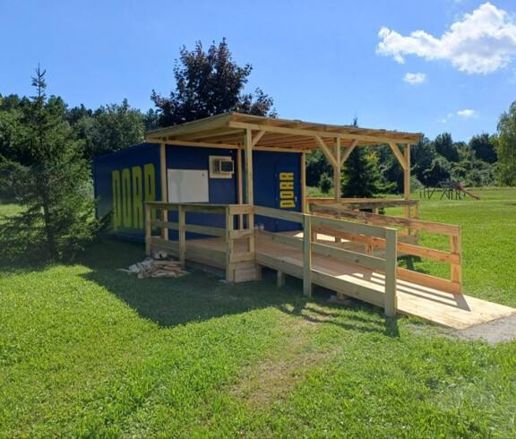 Der Infopoint. Ein Container mit Holzvorbau