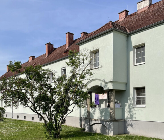 Wohnhaus vor dem ein grüner Baum steht
