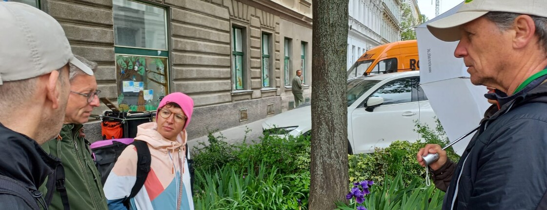 Frei Personen stehen rund neben einem Baum um den Blumen wachsen und reden miteinander