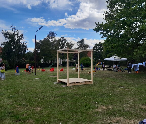 Spielgeräte und Menschen auf einer Wiese