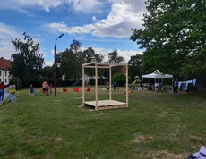 Spielgeräte und Menschen auf einer Wiese